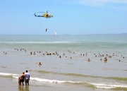 Beach Party Bathers Line Up To Watch the RACQ Capricorn Helicopter Rescue Service In Action-gallery